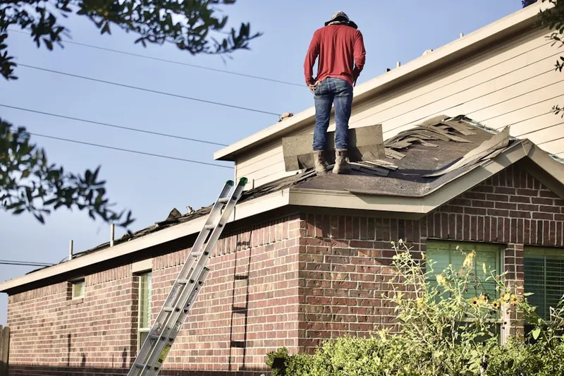 Professional roofer working on a residential roof in August